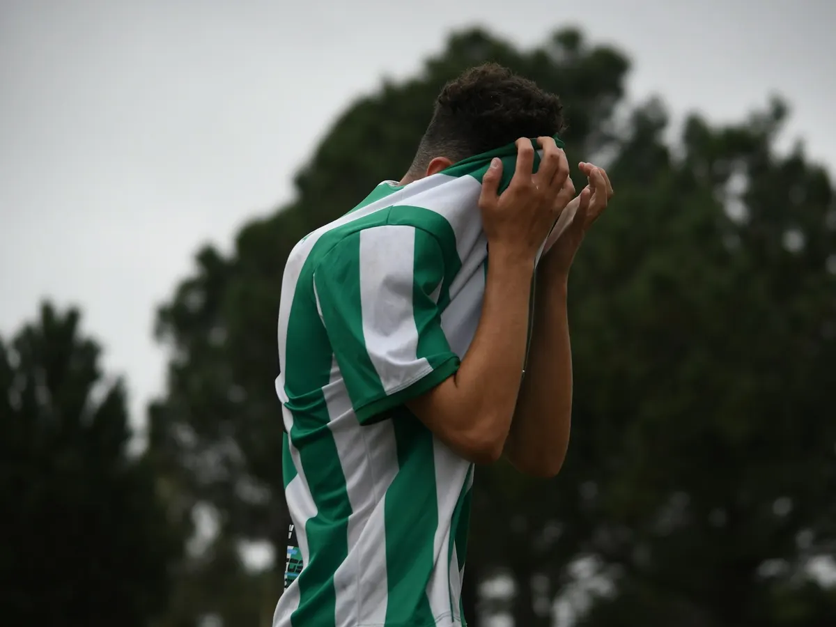 Footballeur, les mains sur le visage après une action manquée