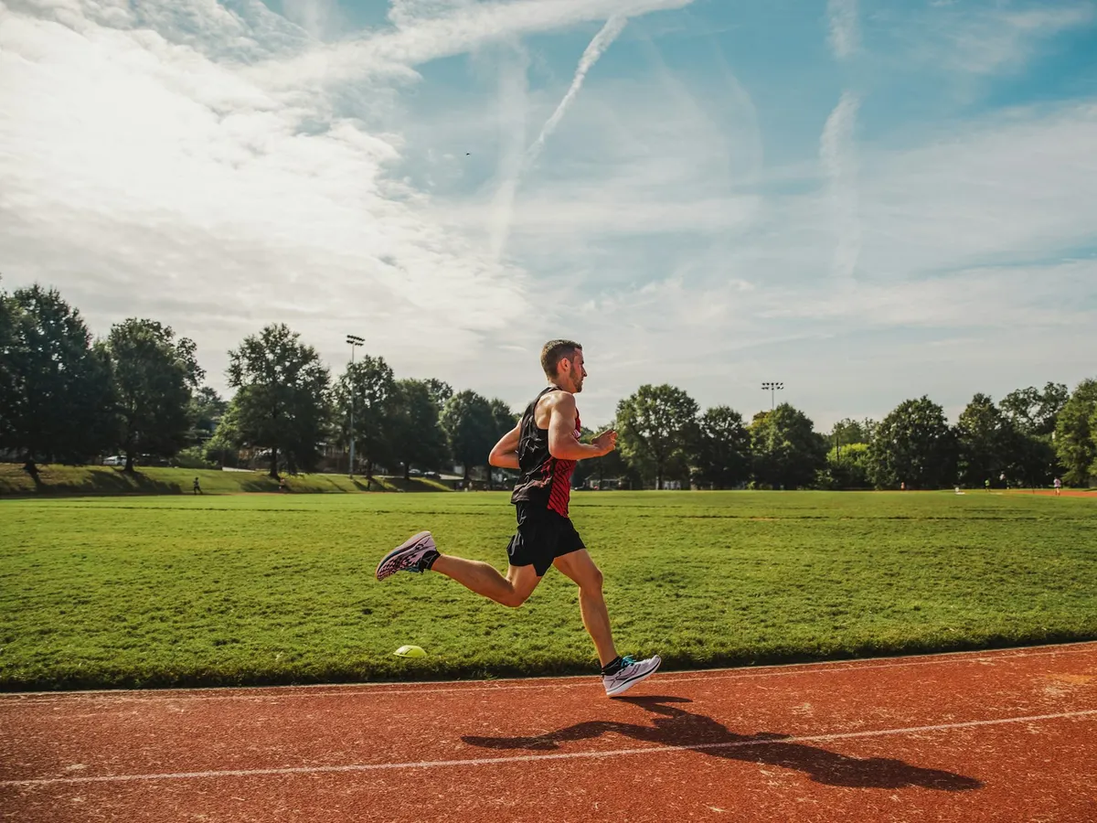 Coureur sur une piste d’athlétisme au soleil